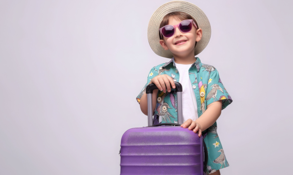 small cheerful child in summer clothes with a suitcase on a white background